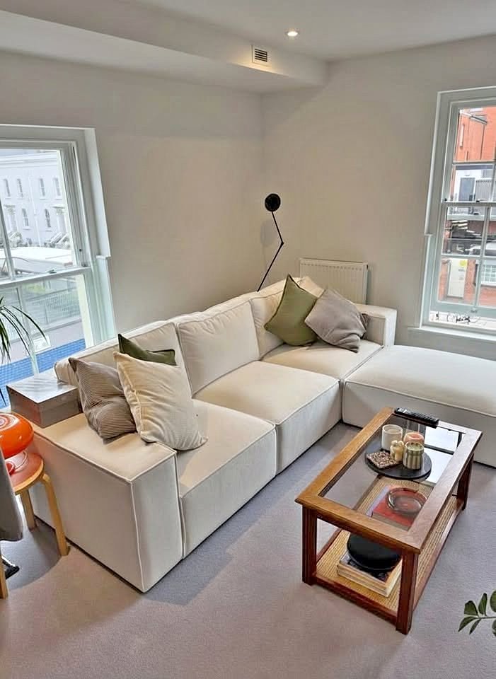 White L-Shaped Sofa with Footstool and Throw Pillows